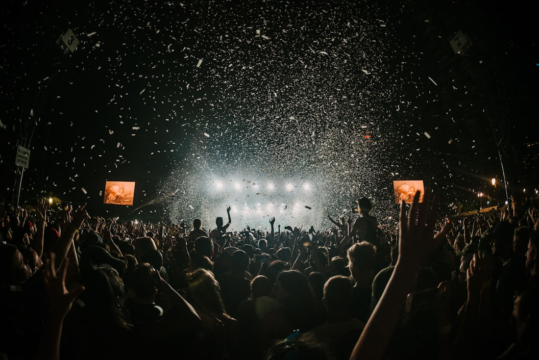 Crowd of people at a summer music festival wearing baseball caps and enjoying live music