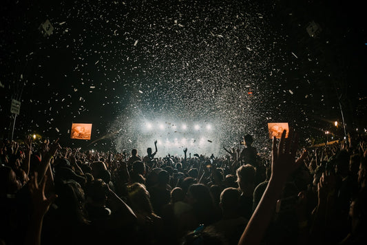 Crowd of people at a summer music festival wearing baseball caps and enjoying live music